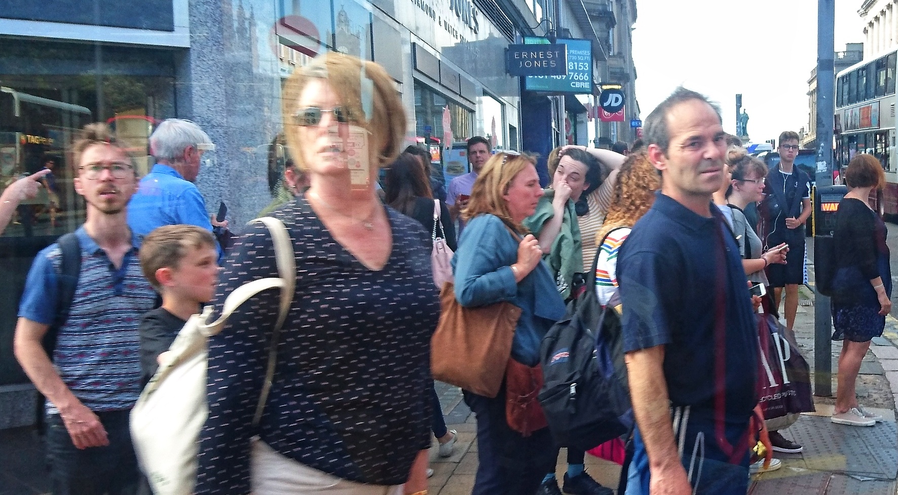Crowds spill across a busy street corner